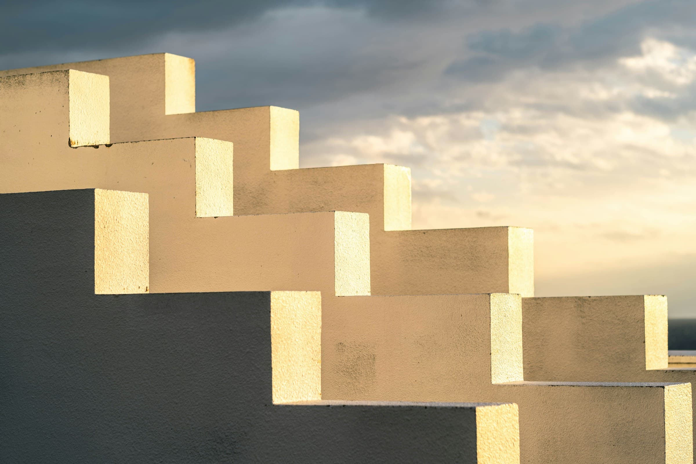 Sunlit concrete steps rising against an evening sky